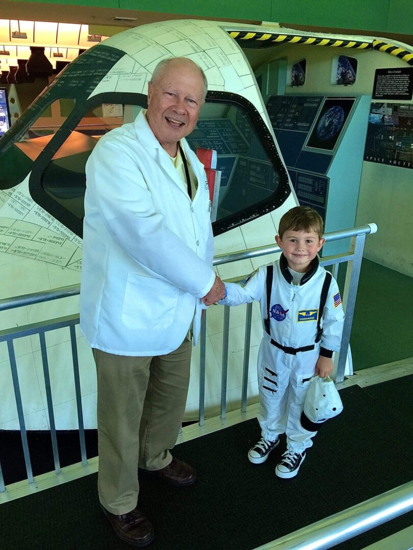A man in a space suit shaking hands with a young boy.